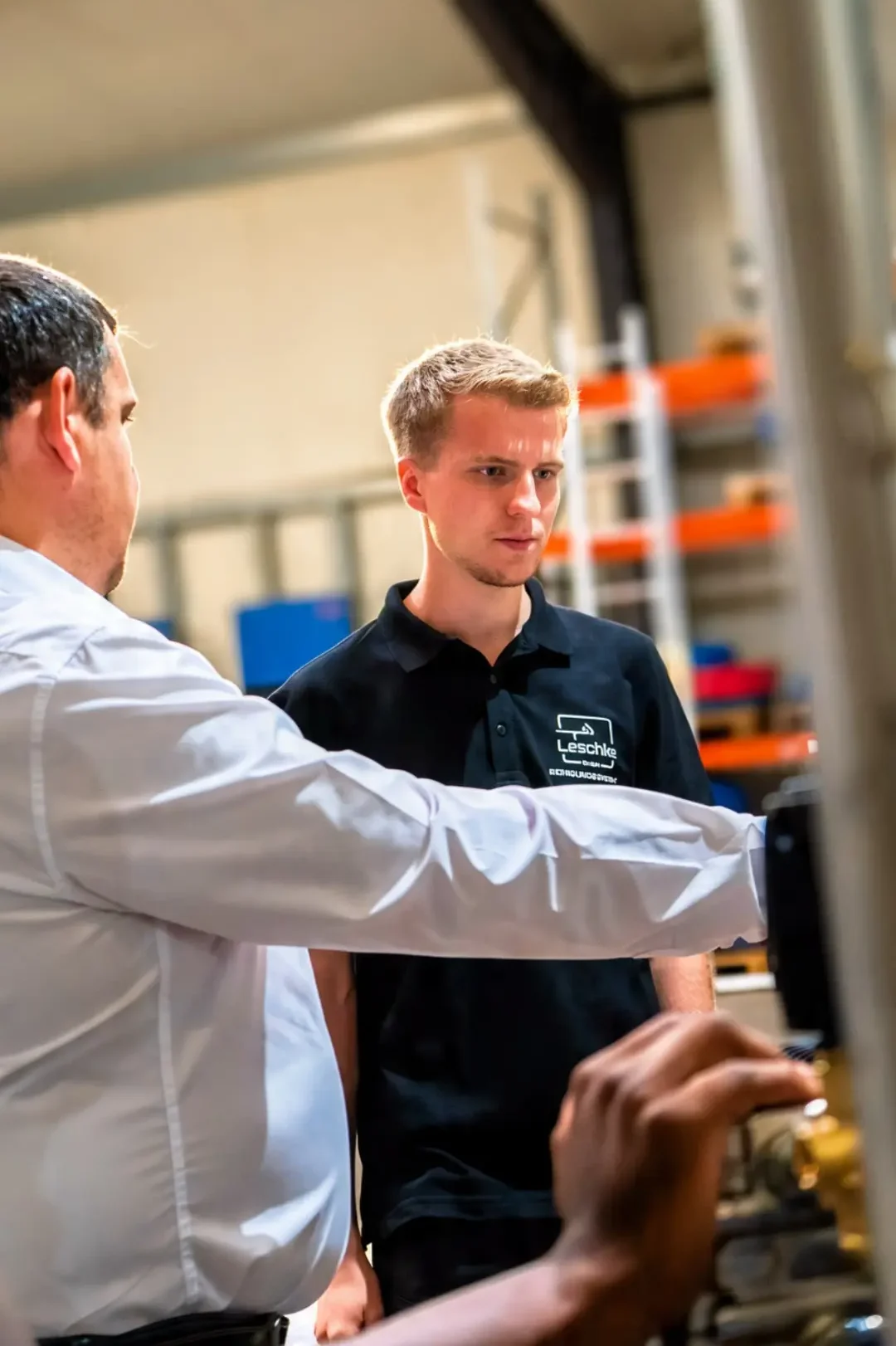 Techniker der Leschke Reinigungssysteme GmbH bei der Besprechung im Ersatzteillager